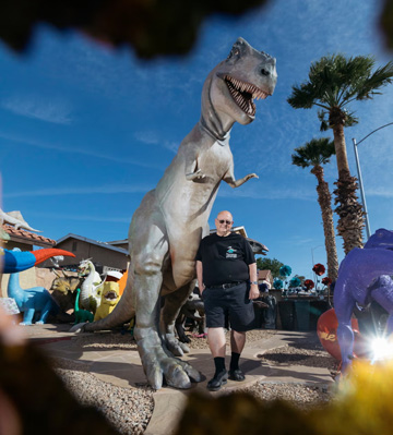 Steve Springer stands with T-Rex dinosaur